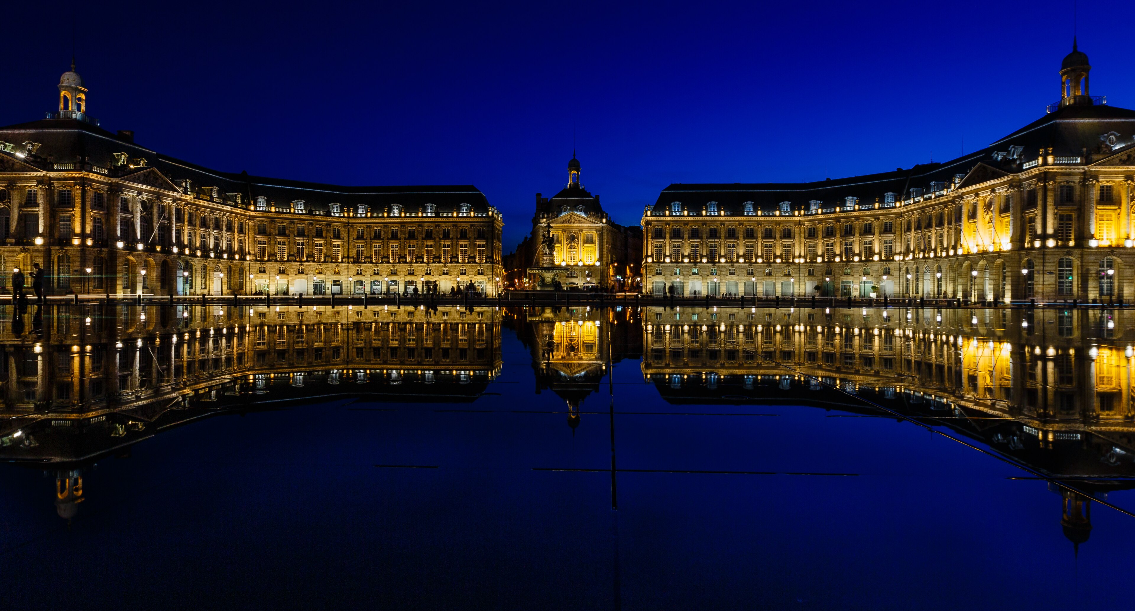 Le miroir d'eau de la place de la Bourse à Bordeaux reflétant les façades en pierre dorée